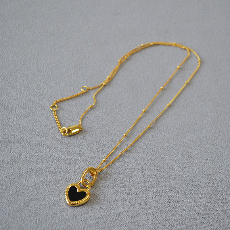 Elegant gold necklace with black and white heart pendants