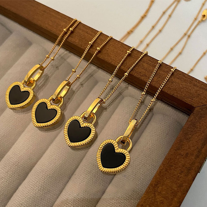 Elegant gold necklace with black and white heart pendants