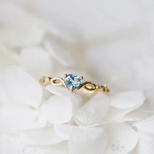 Elegant heart ring made of gold with sparkling blue zirconia stones