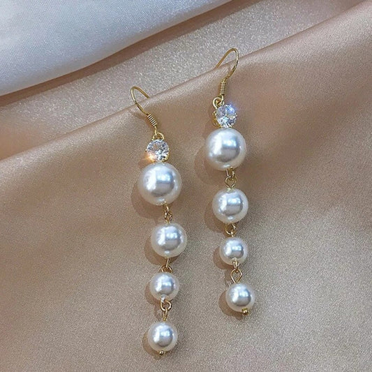 Elegant gold earrings with shimmering pearl pendants