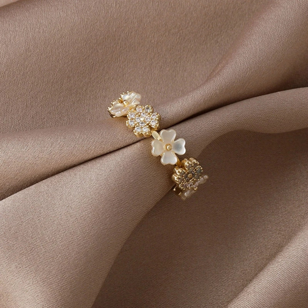 Elegant adjustable gold ring with delicate white flowers and sparkling zirconia stones