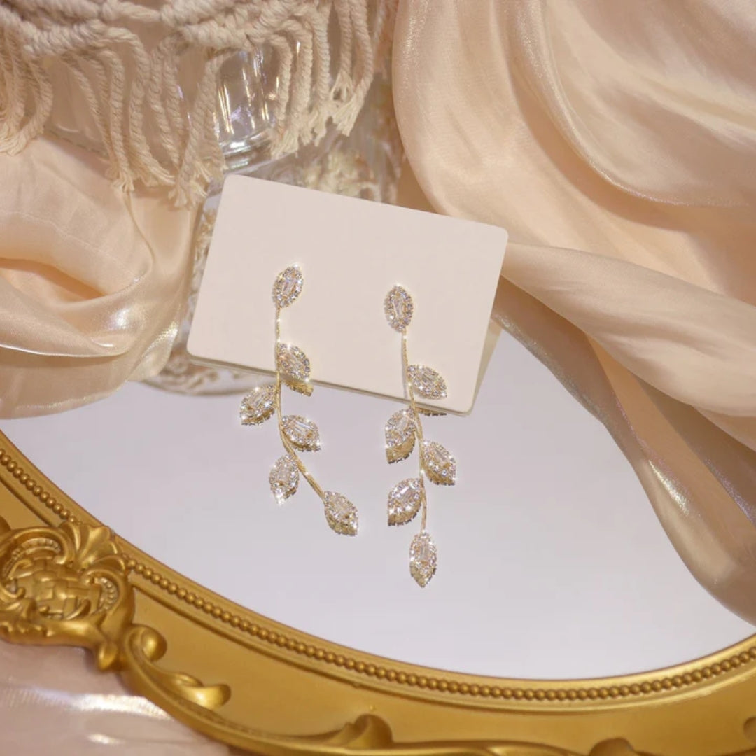 Elegant gold and silver earrings with sparkling zirconia leaf pendant