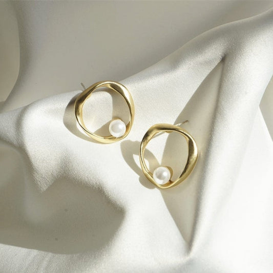 Elegant wave earrings with a shimmering pearl in noble gold