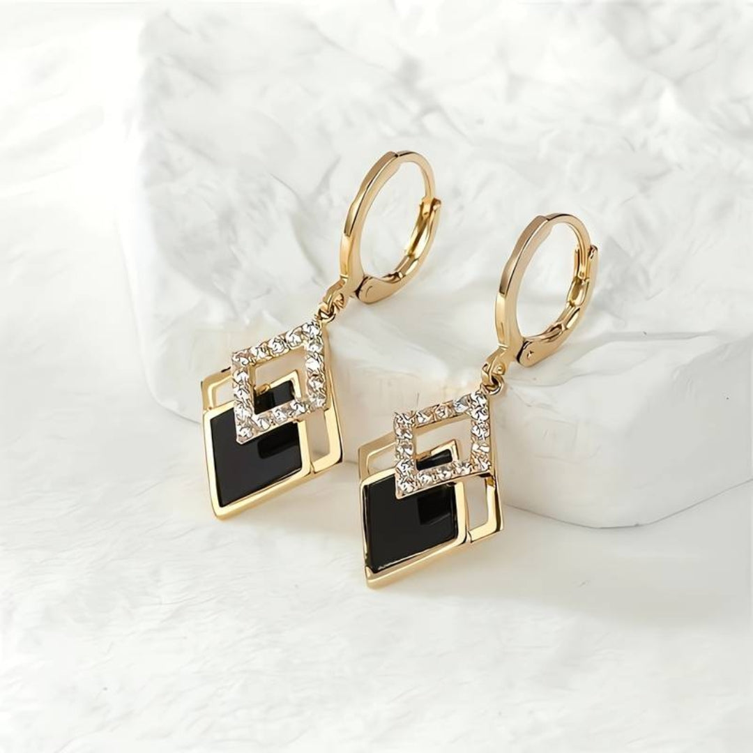 Elegant golden earrings with radiant black shine