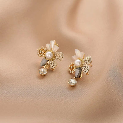 Elegant gold earrings with floral designs and shimmering pearls