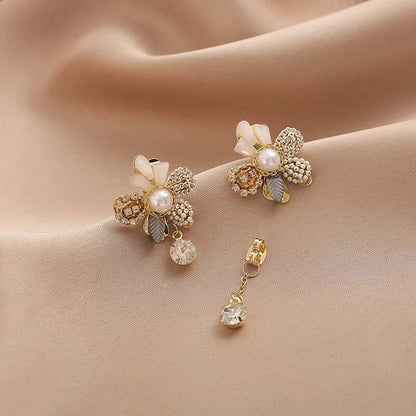 Elegant gold earrings with floral designs and shimmering pearls