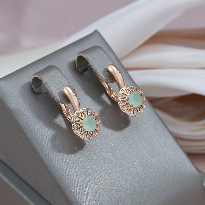 Stylish gold earrings with sparkling zirconia and a green eye-catcher