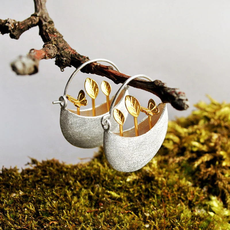 Elegant silver earrings with a gilded flower basket design