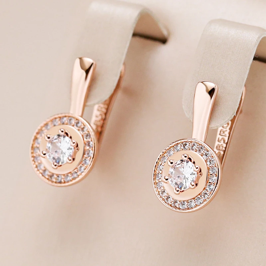 Stylish round earrings made of elegant white crystal in shiny gold