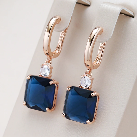 Stylish gold earrings with deep blue crystal