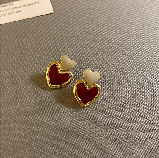 Stylish gold earrings with red enamel hearts