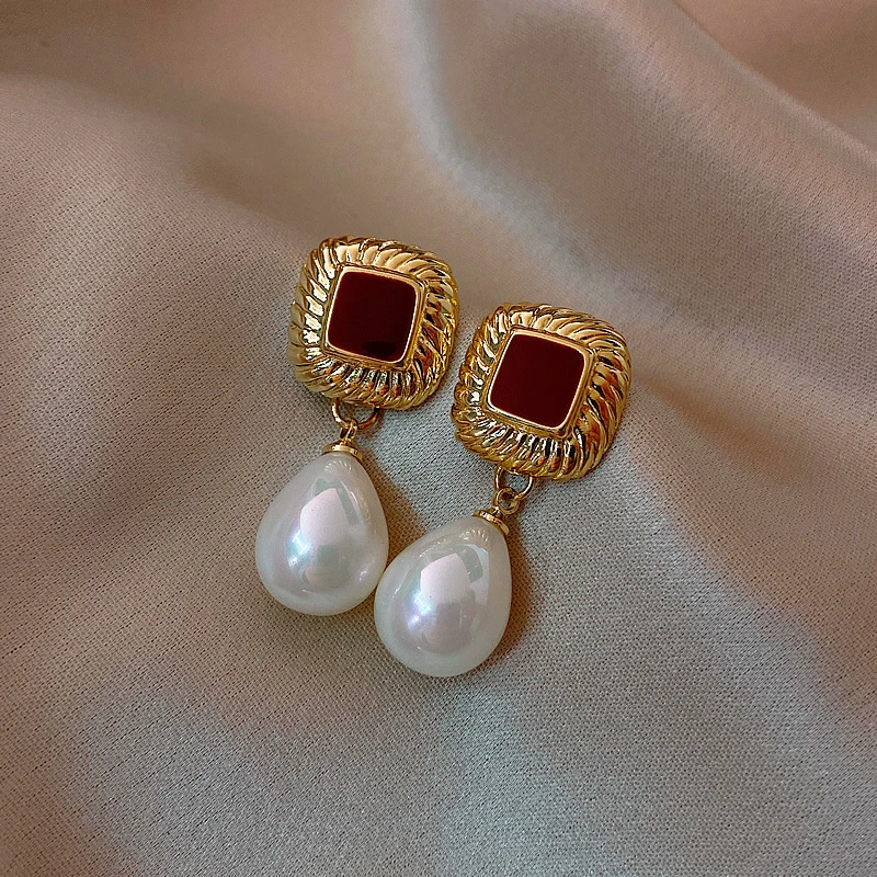 Stylish gold earrings with red accents and elegant pearls