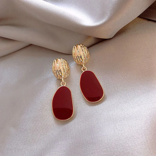 Luxurious gold earrings with red accent