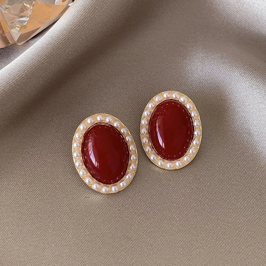 Glamorous oval earrings in luxurious gold and radiant red