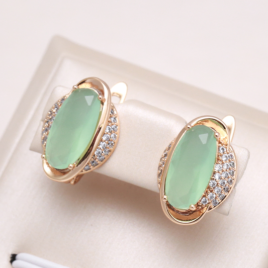 Elegant gold earrings with a radiant green crystal eye